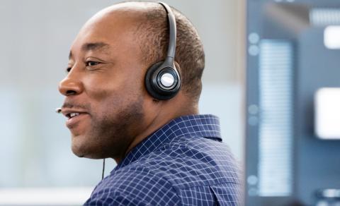 Customer service representative with headphones in an office setting